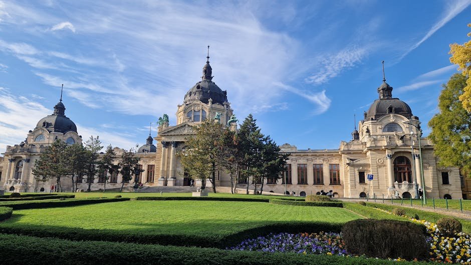 The majestic Széchenyi Thermal Bath under a clear blue sky in Budapest.