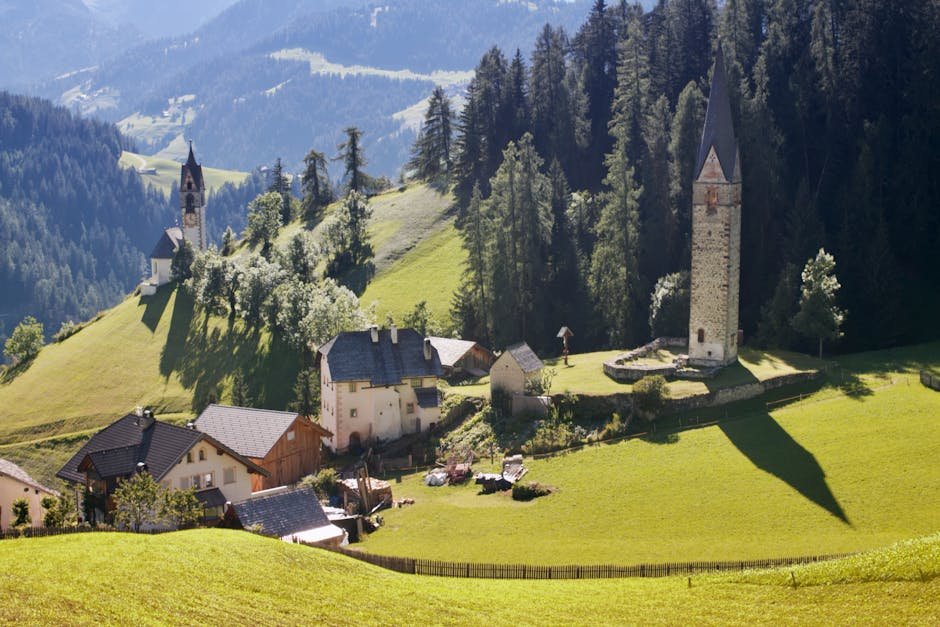 Picturesque landscape of Villnöß Valley with traditional houses and church amidst lush greenery in Trentino-Alto Adige, Italy.